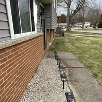 After: Landscape bed along the brick cleared and rocked, with path lights