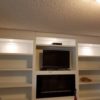 Built-in entertainment center with fireplace and lit shelves